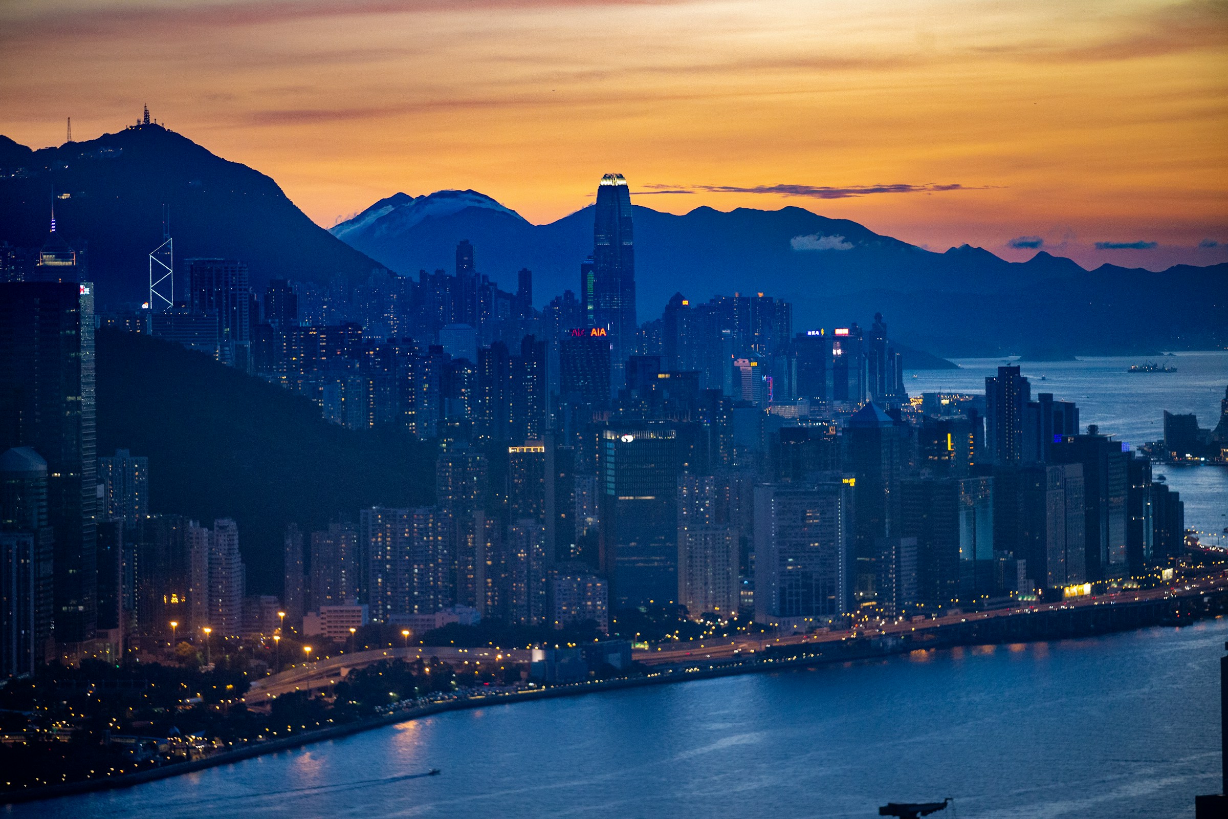 Hong Kong towers and harbor at dusk.